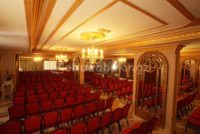 Imperial Hall with red chairs, elegant chandeliers for conferences and meetings.