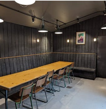 Cozy minimalist meeting space with wooden table for corporate hire in Blackpit Brewer.