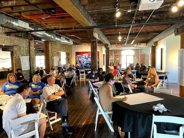 "Fine Arts Gallery meeting with attendees engaged in discussion, ideal for networking events."