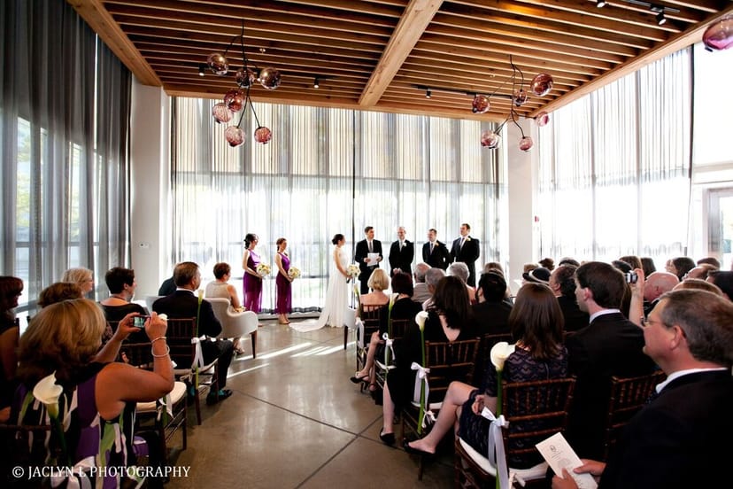 Elegant wedding ceremony setup in modern Catalyst Restaurant patio with floral decor.