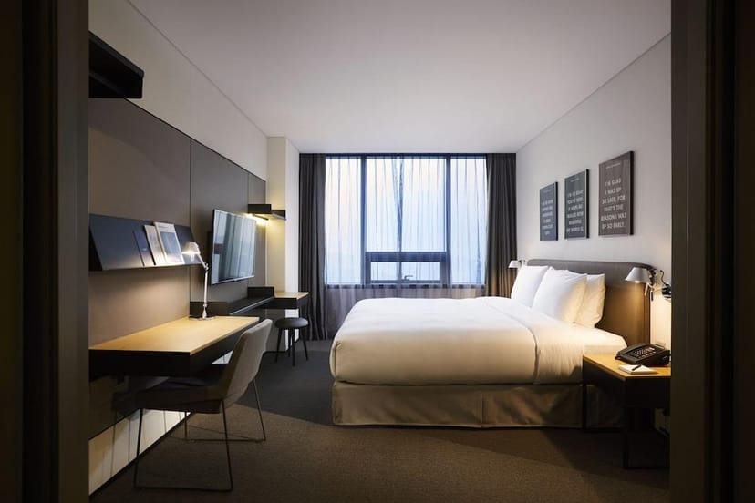 Modern hotel room with king-sized bed, ideal for business retreats and events.