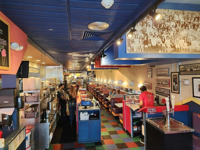 Vibrant diner booth at Johnny's Luncheonette, perfect for casual meetings and gatherings.