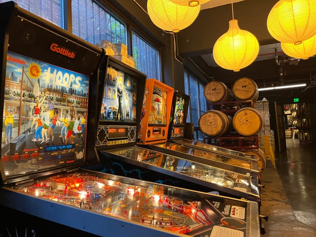 Vibrant cocktail bar with vintage pinball machines for networking events and team-building.