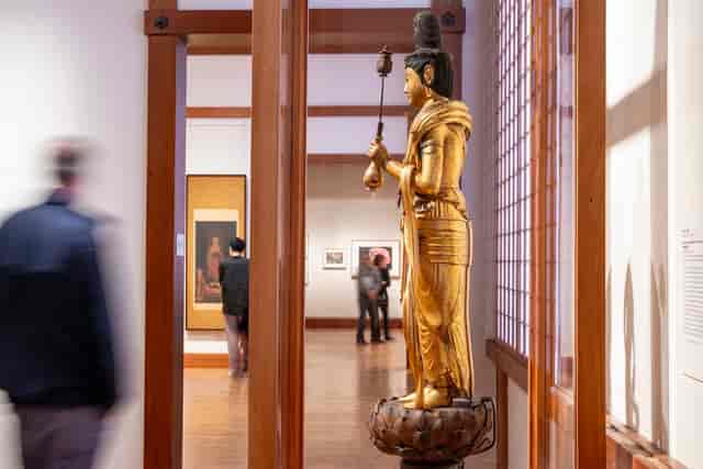 Statue in Boston art gallery, warm wood decor, ideal for events and exhibitions.