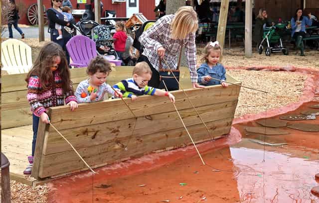 Children fishing in a vibrant outdoor event space at Davis Farmland group outing.