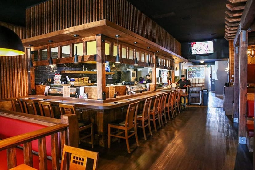 Warm sushi restaurant interior with wooden accents, perfect for gatherings and meetings.