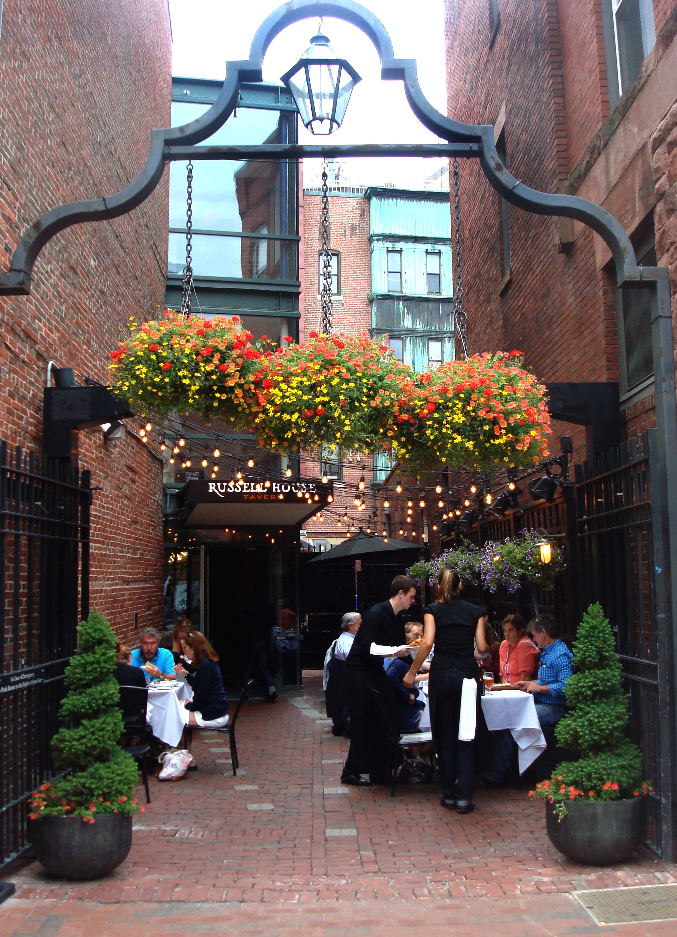 Charming outdoor bar at Russell House Tavern with vibrant flowers, ideal for events.