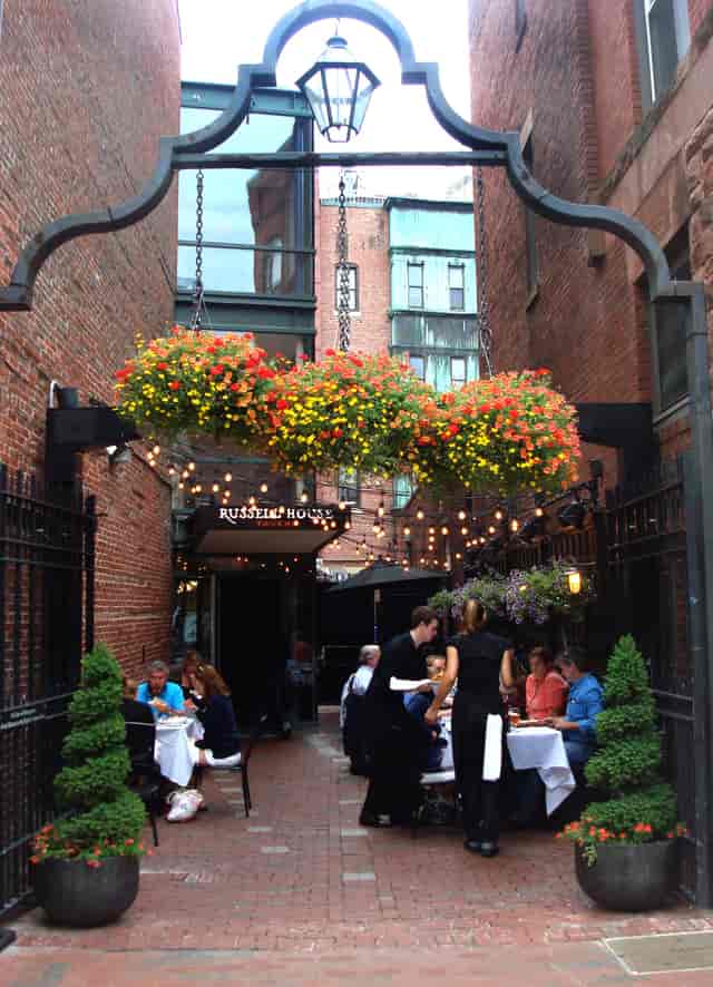 Charming outdoor bar at Russell House Tavern with vibrant flowers, ideal for events.