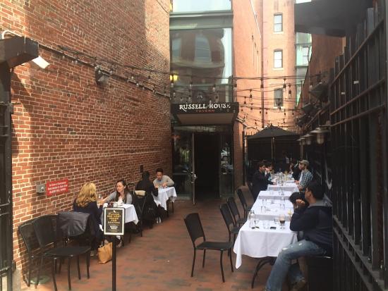Outdoor dining at Russell House Tavern with brick walls, ideal for gatherings and events.