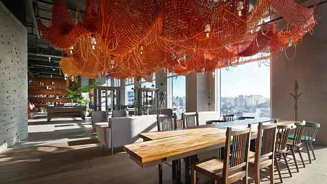 Modern event space at L7 HONGDAE by LOTTE with artistic ceiling, ideal for meetings and gatherings.