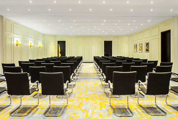 Modern conference hall with sleek black chairs, ideal for corporate meetings and workshops.