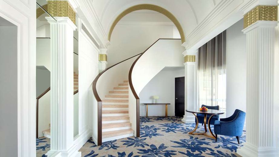 Elegant meeting room with sweeping staircase at Radisson Blu, ideal for corporate events.