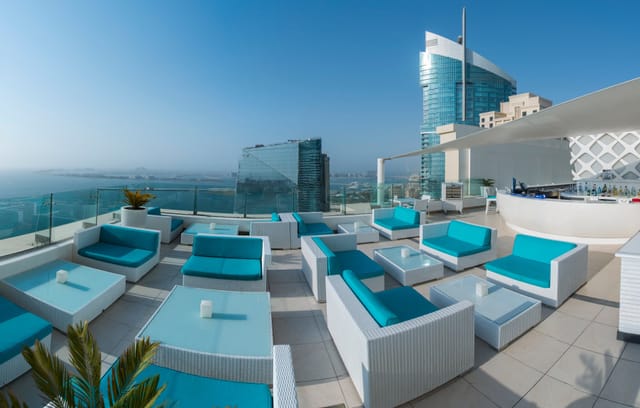 Sky bar at Hilton Dubai: stylish rooftop venue with turquoise furniture for upscale events.