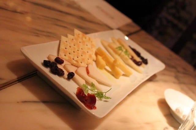 Elegant cheese platter with crackers and dried fruits for networking events in Spain.