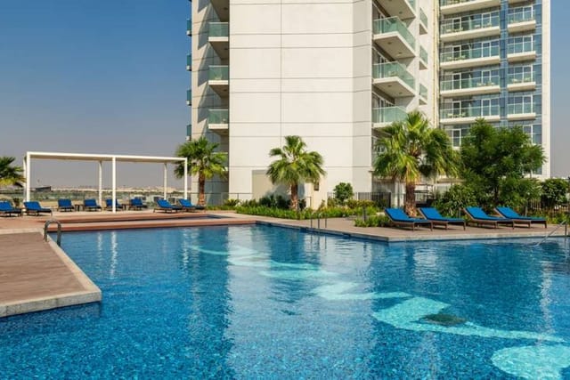 Birdie by a pristine pool at Radisson Hotel Dubai, perfect for corporate events and relaxation.