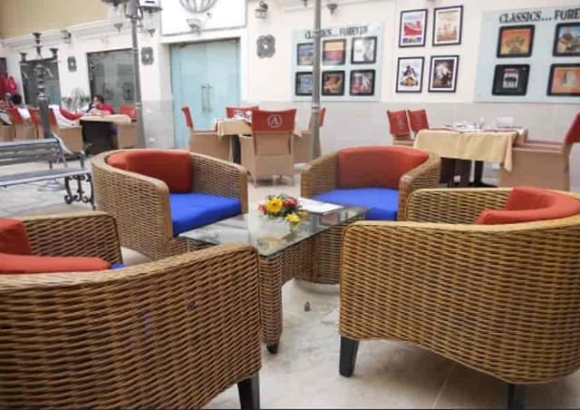 Cozy rooftop bar at Hotel Aroma with wicker chairs, ideal for networking events.