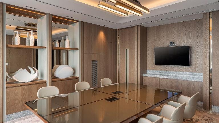 Modern meeting room with sleek table, ideal for corporate events and gatherings.