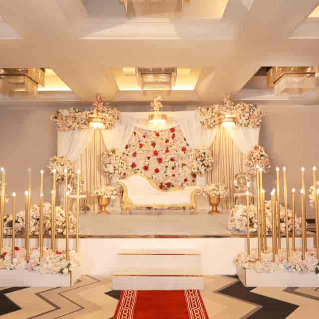 Elegant conference hall stage with floral backdrop, ideal for weddings and upscale events.