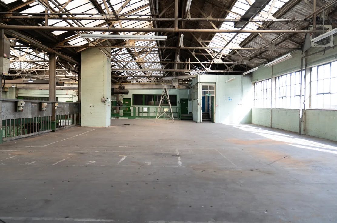 Spacious industrial venue with high ceilings for creative events and workshops.