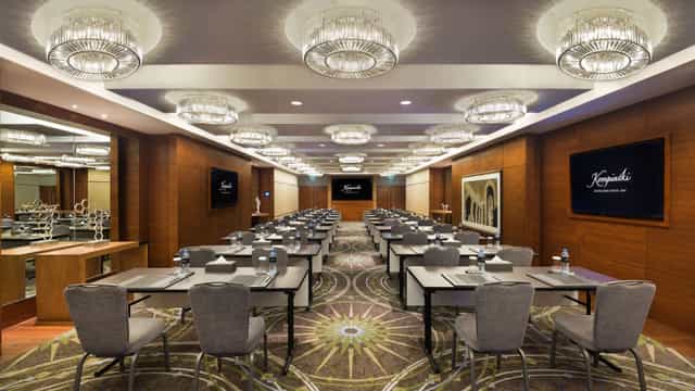 Kempinski Hotel meeting room with elegant chandeliers for corporate events and training sessions.