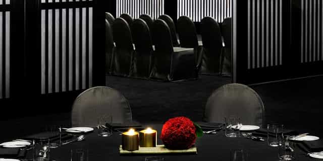 Elegant dining setup with red flowers in Armani Hotel Dubai event space.