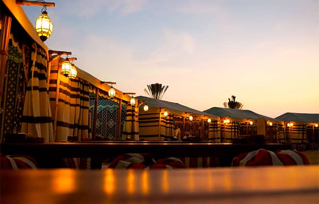 Outdoor event space at sunset with elegant tents by OceanAir Travel & Tourism LLC.