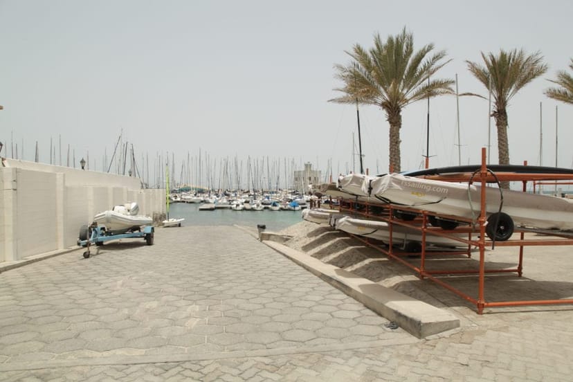 The Loft at Dubai Offshore Sailing Club: serene marina, palm trees, outdoor events.