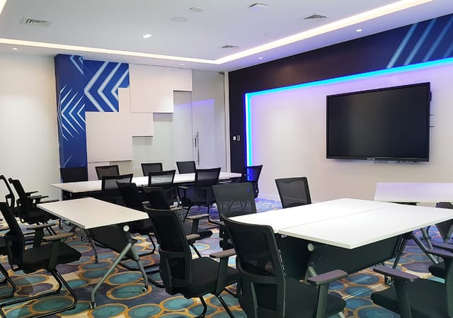 Modern training room with movable tables, ideal for workshops and presentations.