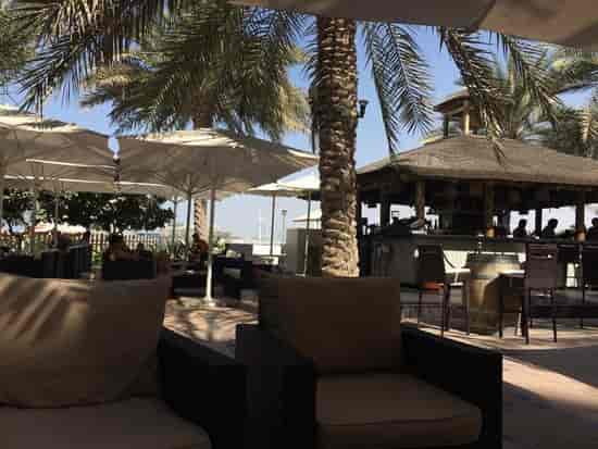 Stylish outdoor bar at Riva Beach, perfect for casual networking events with palm trees.