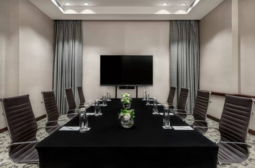 Modern conference room in The H Dubai with a long black table for corporate meetings.