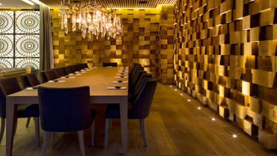 Private dining room with wooden table and plush chairs for executive meetings or events.