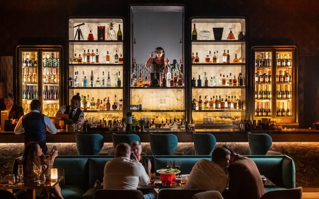 Stylish lounge bar with inviting spirits display, perfect for networking events and cocktail receptions.
