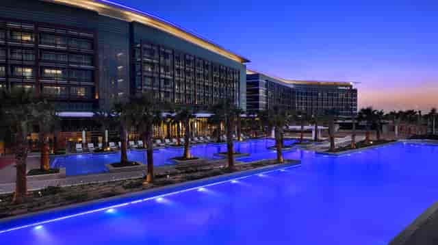 Al Forsan Sports Resort hotel with lit pool, perfect for upscale events and gatherings.