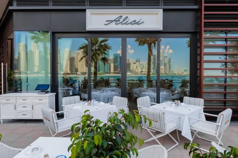 Stylish outdoor dining at Alici with waterfront view, perfect for upscale events.