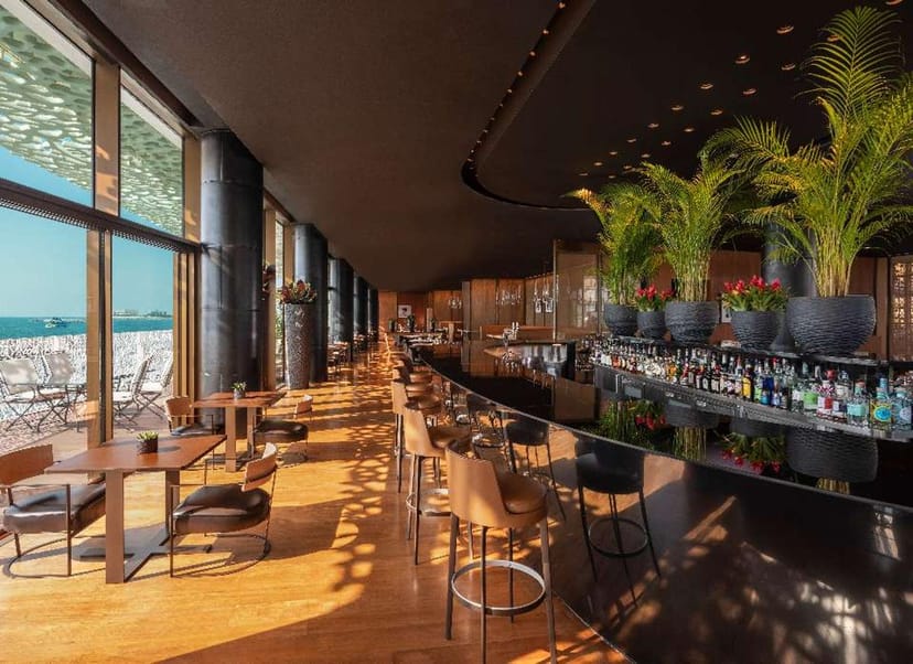 Sleek cocktail bar with waterfront view, perfect for upscale events and gatherings.