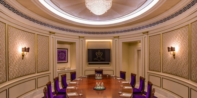 Luxurious boardroom with round table and purple chairs at Palazzo Versace Dubai.