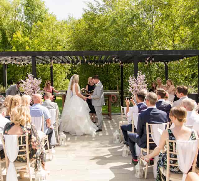 Outdoor wedding ceremony setup at Holiday Inn London Shepperton featuring an elegant floral pergola.