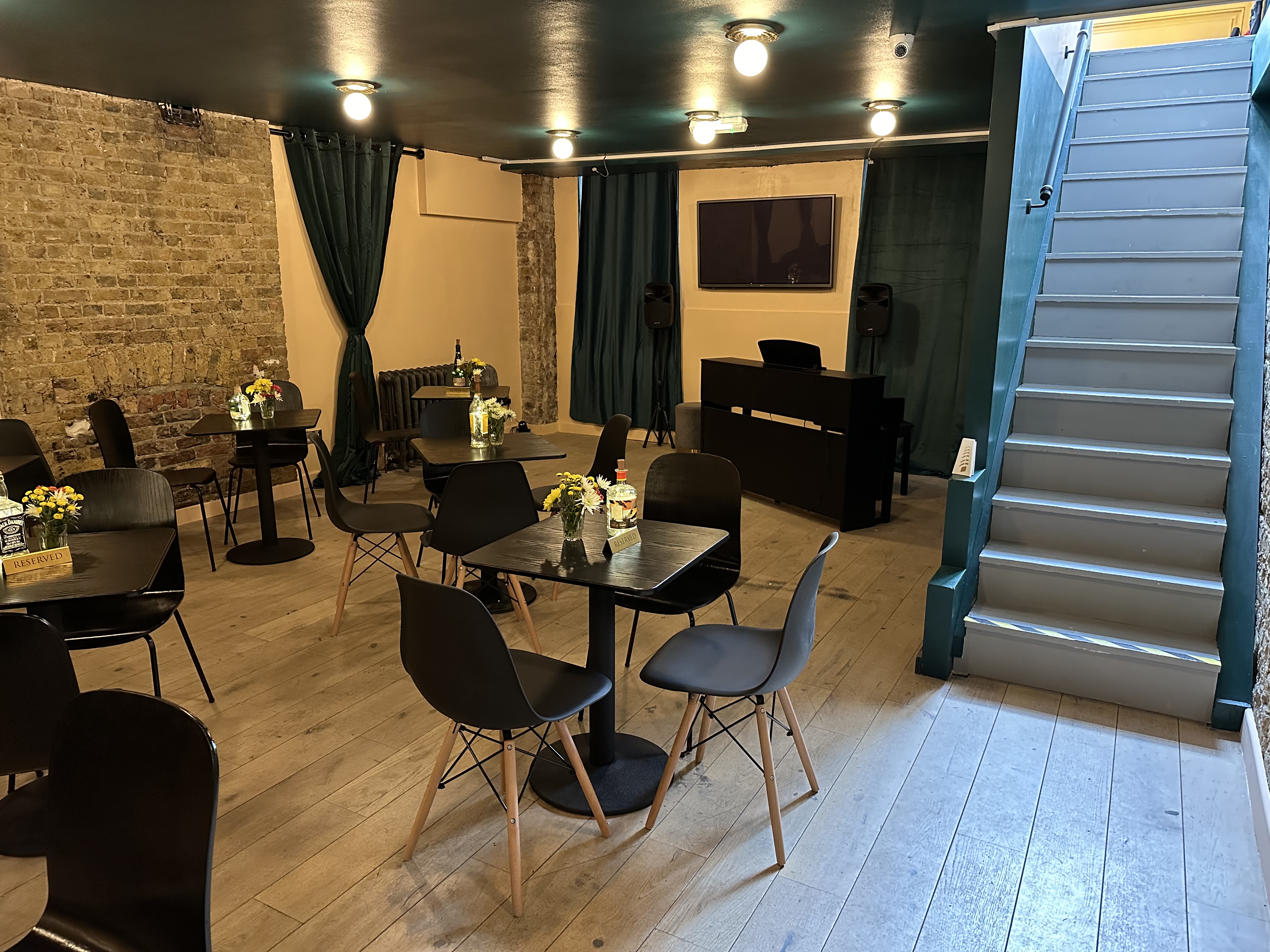 Versatile event space with black chairs, ideal for meetings and workshops at Libra Theatre Cafe.