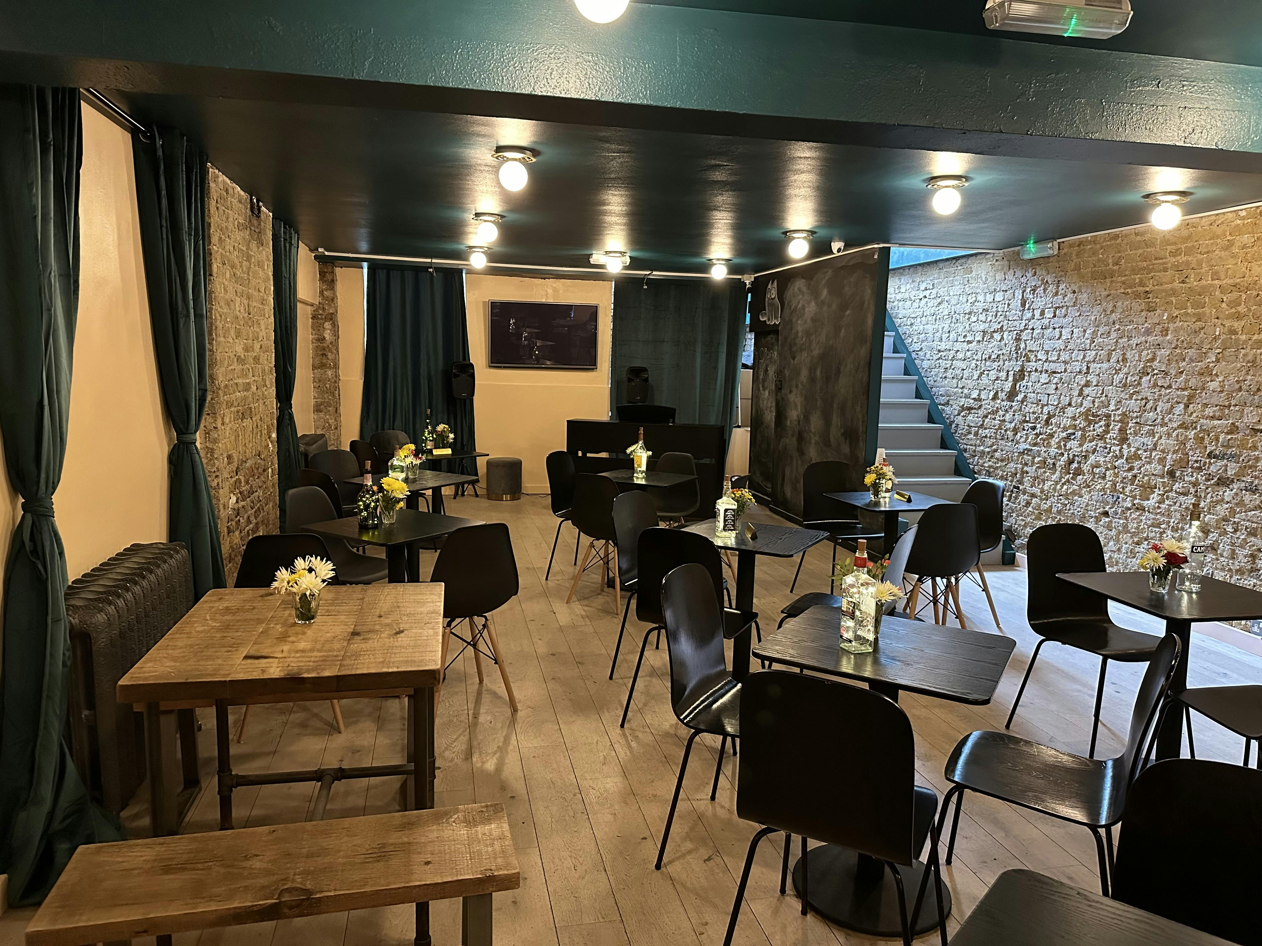 Cozy event space with wooden tables, ideal for meetings and workshops at Libra Theatre Cafe.
