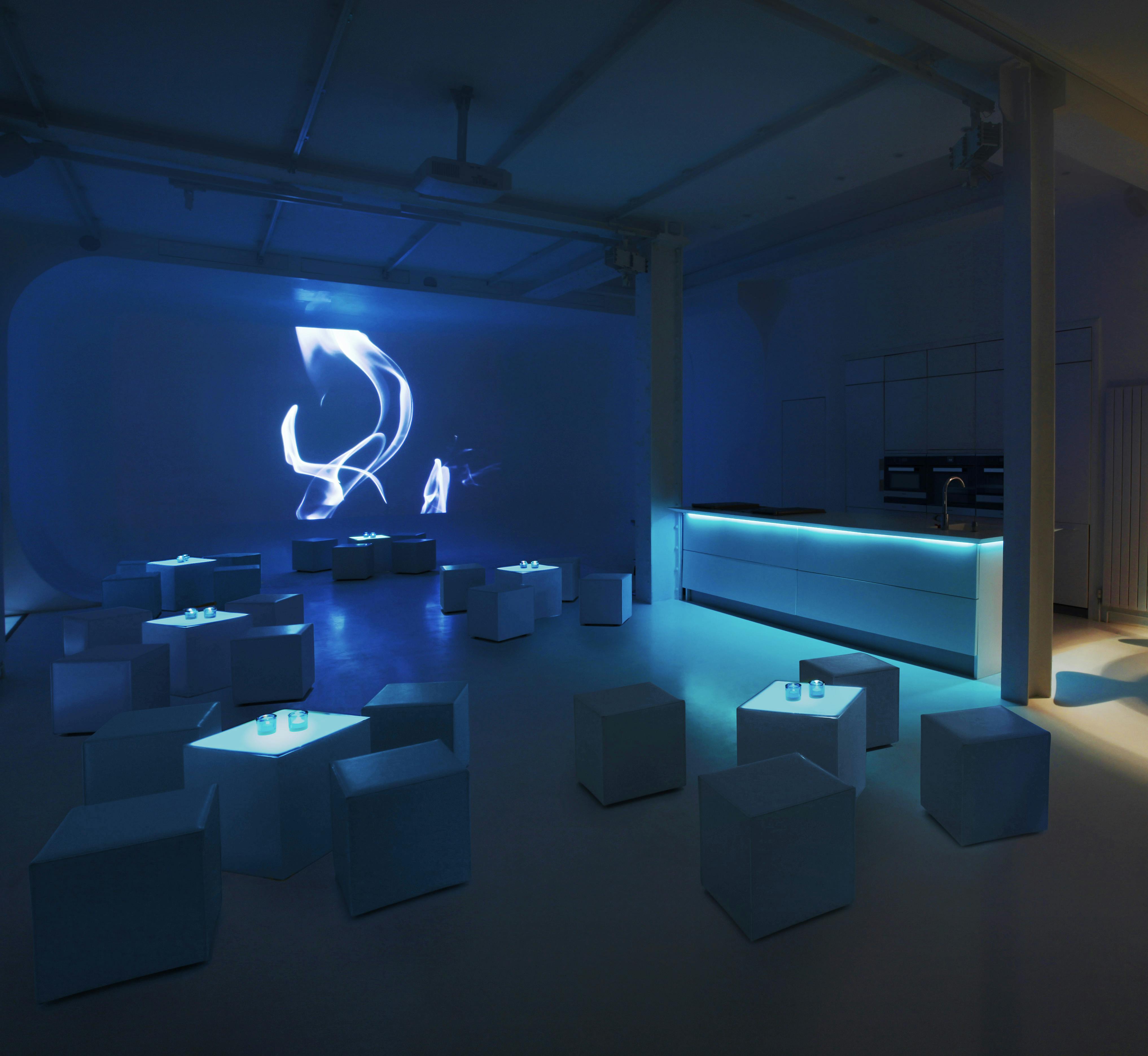 Modern event space with blue lighting for cocktail receptions and networking events.