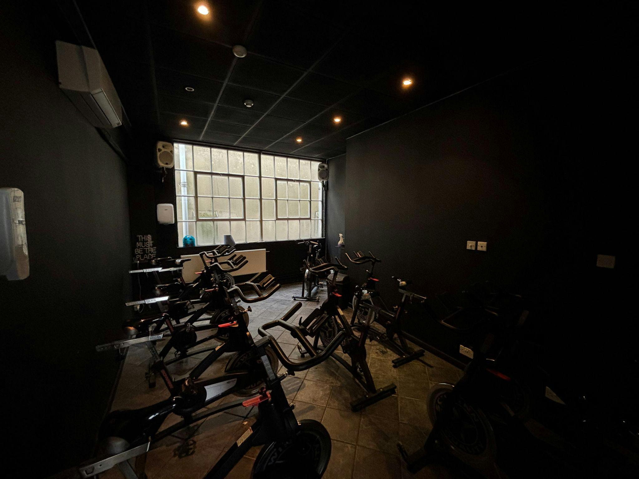 Modern fitness studio with dark walls, ideal for cycling classes and wellness events.