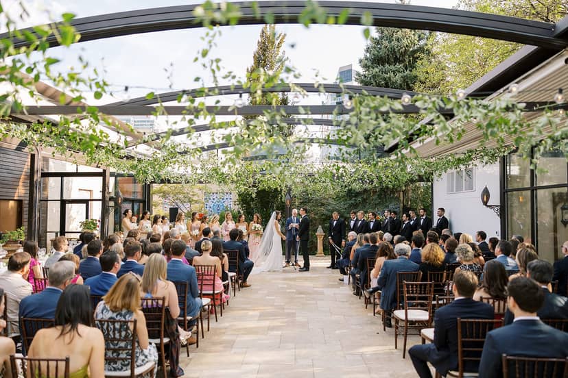 Outdoor wedding ceremony at Galleria Marchetti with elegant glass pavilion and greenery.