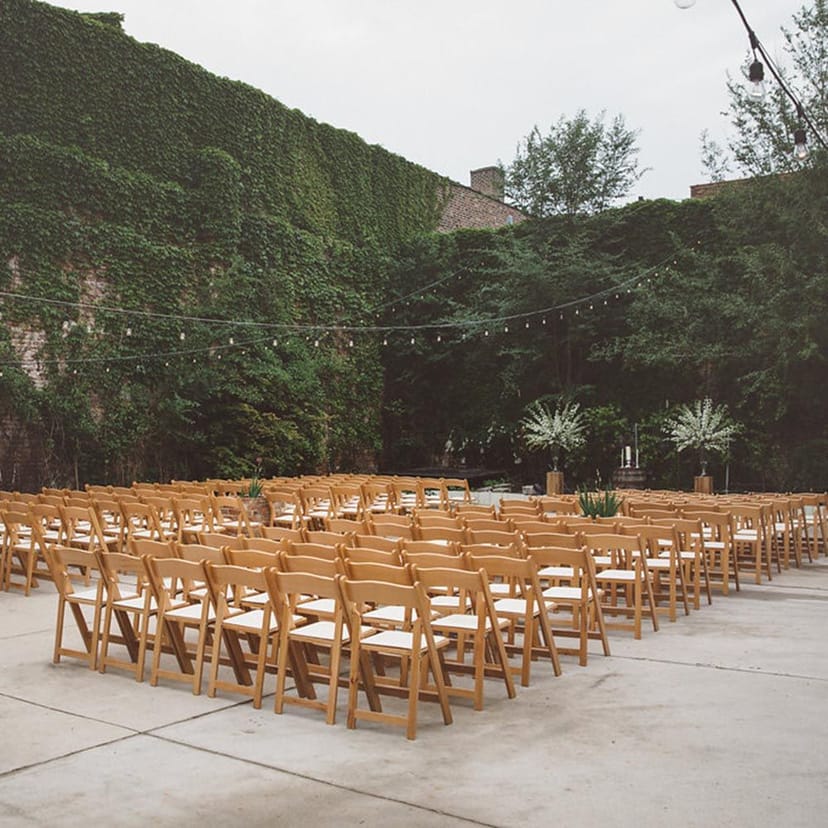 Outdoor wedding venue with wooden chairs and elegant string lights at City Winery Chicago.