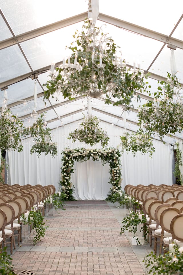 Elegant tented wedding venue with floral arch and chandeliers in Chicago.