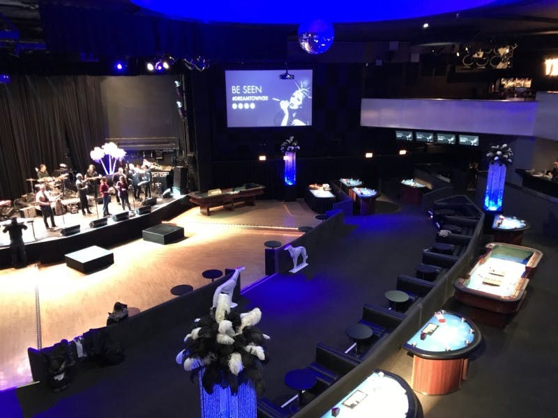 Stylish Park West theater with stage and gaming tables for corporate events and gatherings.