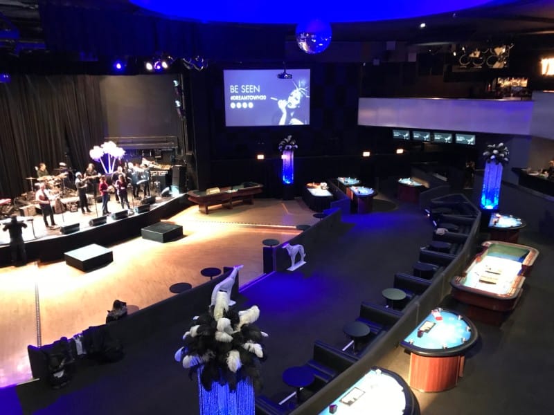Stylish Park West theater with stage and gaming tables for corporate events and gatherings.