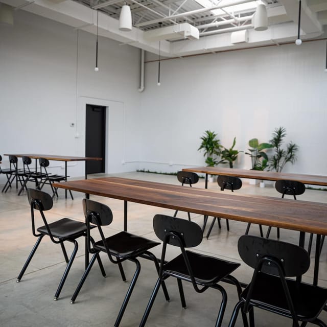 East Studio in Lytle Auditorium: minimalist event space with wooden tables, ideal for workshops.