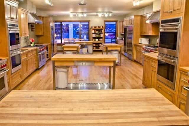 Spacious cooking school kitchen with modern appliances for culinary workshops and team-building.