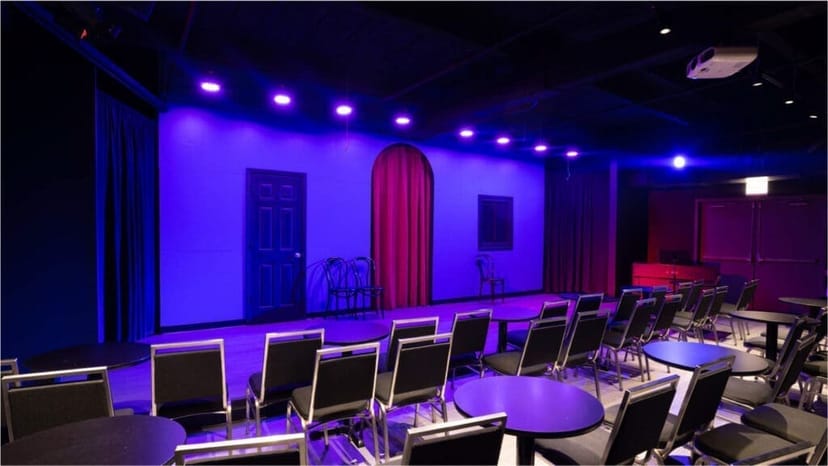 Versatile event space at iO Theater with stage and dramatic lighting for performances.