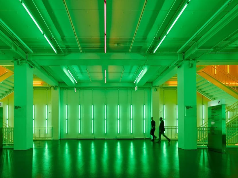 Modern event space in Harris Theater with vibrant green and orange lighting.